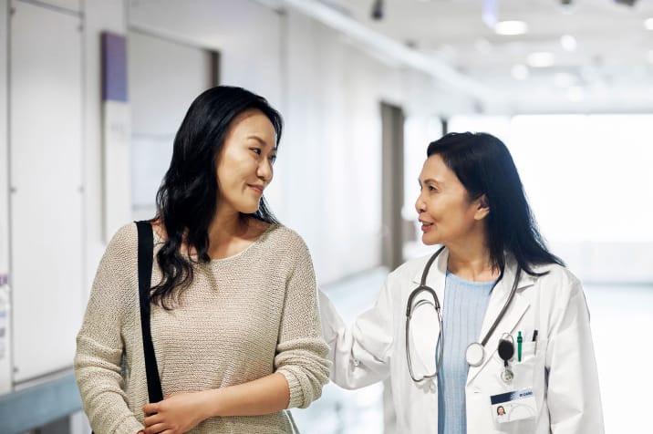 Doctor and patient walking in hospital hallway